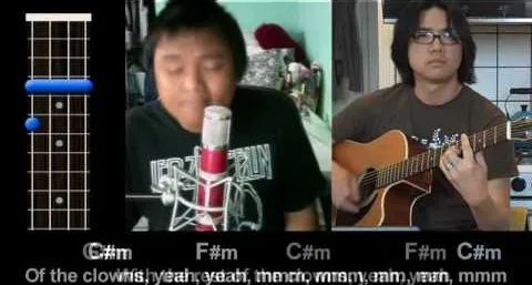 Two musicians performing a song; one is singing into a microphone while the other plays guitar.