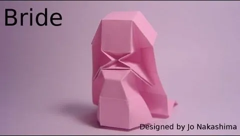 Origami sculpture of a bride in pink.