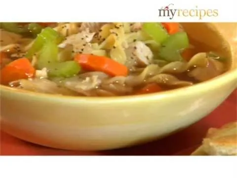 Bowl of vegetable and chicken noodle soup with carrots and celery.