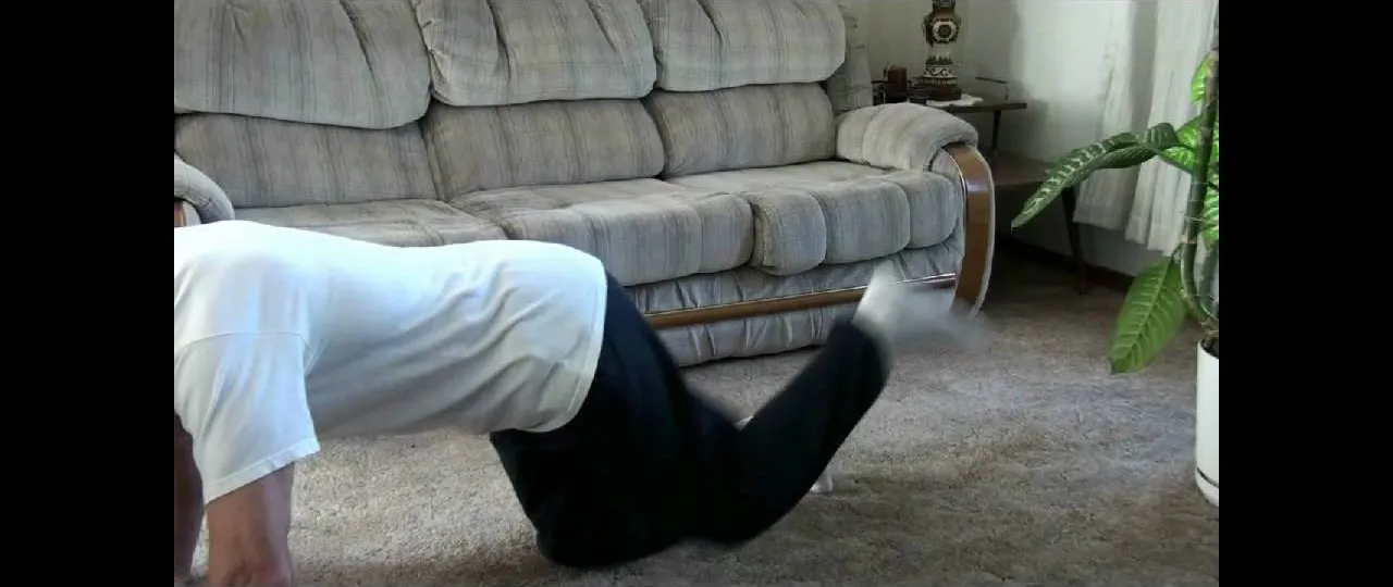 Person performing an exercise on a carpeted floor in a living room setting.