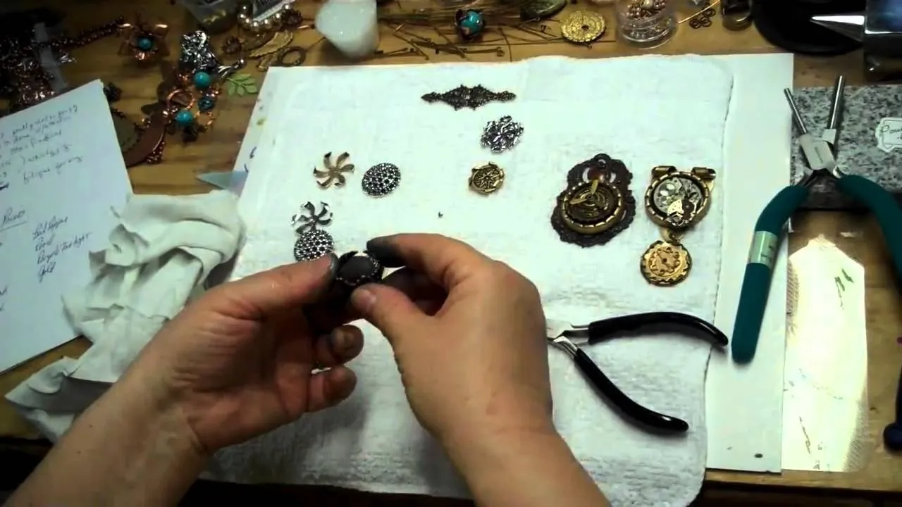 Jewelry-making tools and brooches on a work surface.