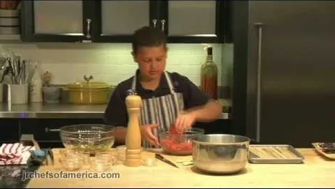Young chef preparing meat in a modern kitchen.
