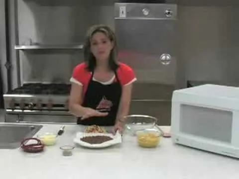 Woman demonstrating a dessert recipe in a kitchen setting.