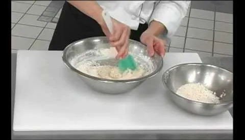 A chef mixing ingredients in a bowl with a spatula.