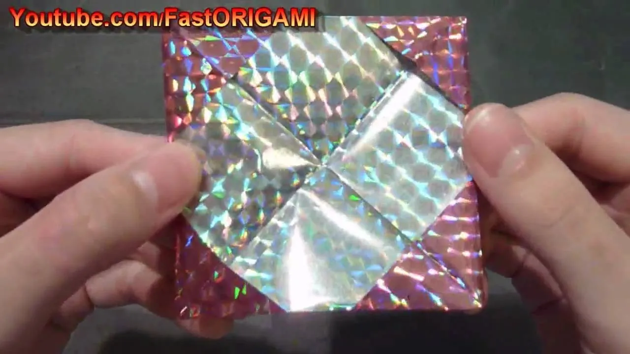 Holographic origami artwork being held by hands.