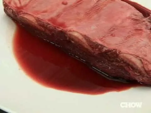 Juicy steak on a plate with red sauce.