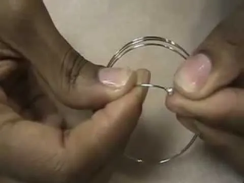 Hands holding and manipulating a wire hoop.
