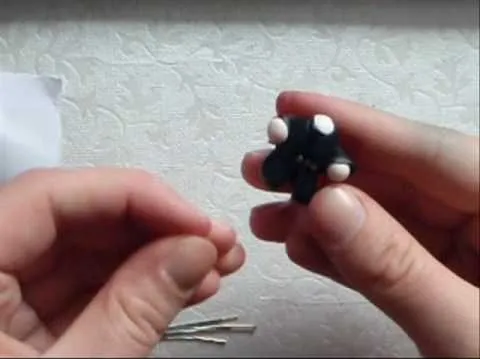 Hand holding a small black and white figurine.