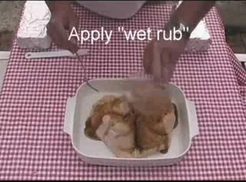 Applying wet rub to chicken in a dish.