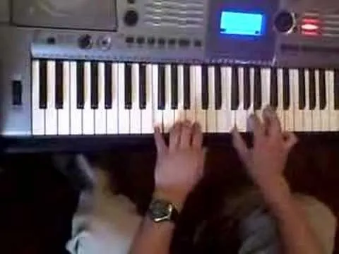 A top-down view of hands playing a keyboard instrument.