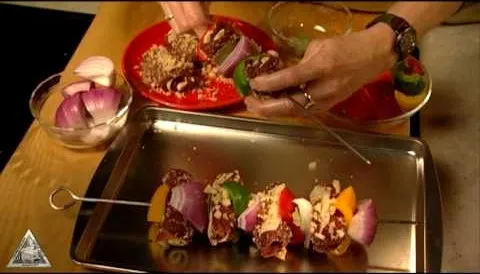 Grilling skewers being prepared with colorful vegetables and meat.
