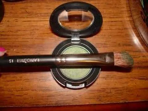 Makeup brush and green eyeshadow in compact.