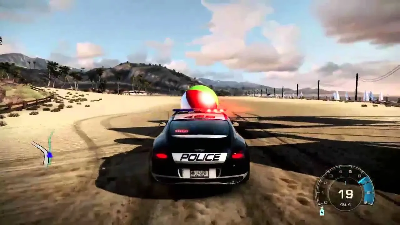 Police car driving on a sandy terrain under a blue sky.