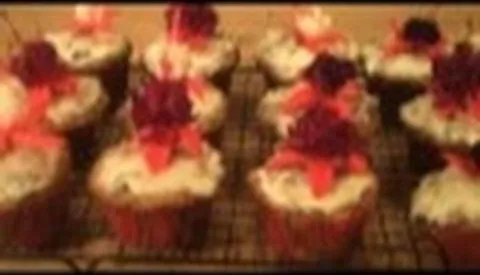 Frosted cupcakes decorated with colorful flowers.