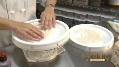Chef shaping dough in a professional kitchen setting.