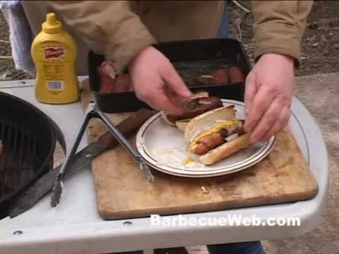 Grilling hot dogs with mustard on a plate.