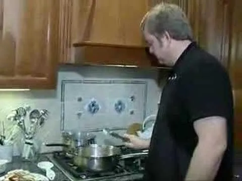 A person cooking in a kitchen with pots on the stove.