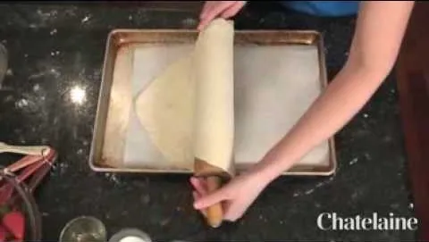 Rolling out dough on a baking sheet.