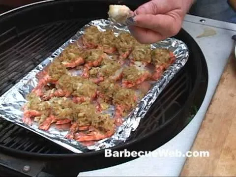 Grilled shrimp on a foil tray with seasoning.