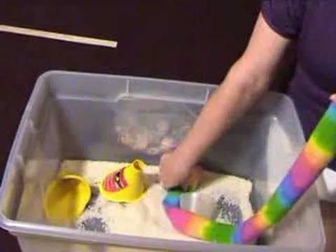 Colorful sensory bin with sand and toys for children.