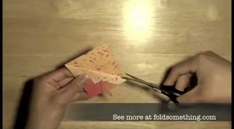 A person cutting colored paper for a crafting project.