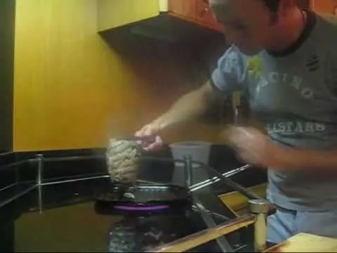Person cooking on a stovetop.