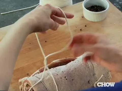 Cooking process: tying meat with kitchen twine.