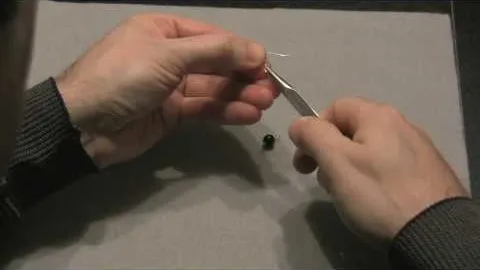 A person using tweezers to manipulate a small object.