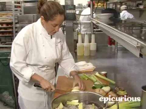 A chef skillfully preparing vegetables in a professional kitchen.