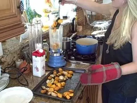 Woman preparing roasted vegetables in a kitchen.