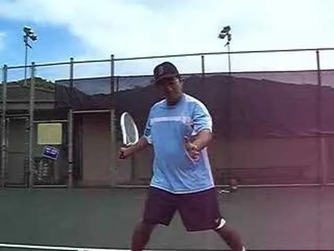 Man preparing to serve on a tennis court.