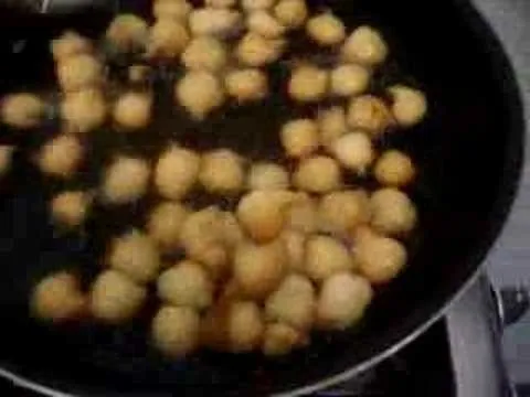 Frying small golden-brown balls in a pan.