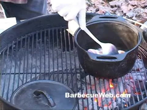 Cooking in a campfire with a pot on a grill.