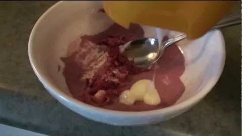 Bowl of mixed ingredients including diced meat, sauce, and a spoon.