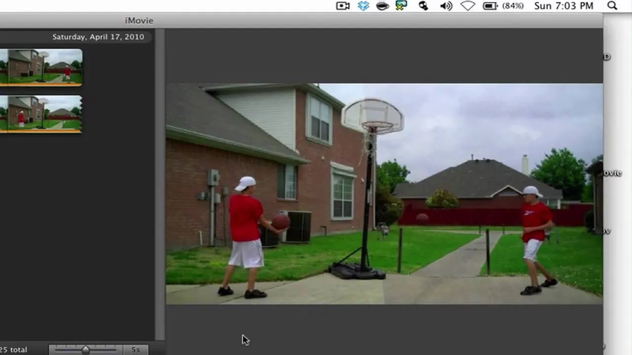 A boy shooting basketball in a driveway with a hoop.