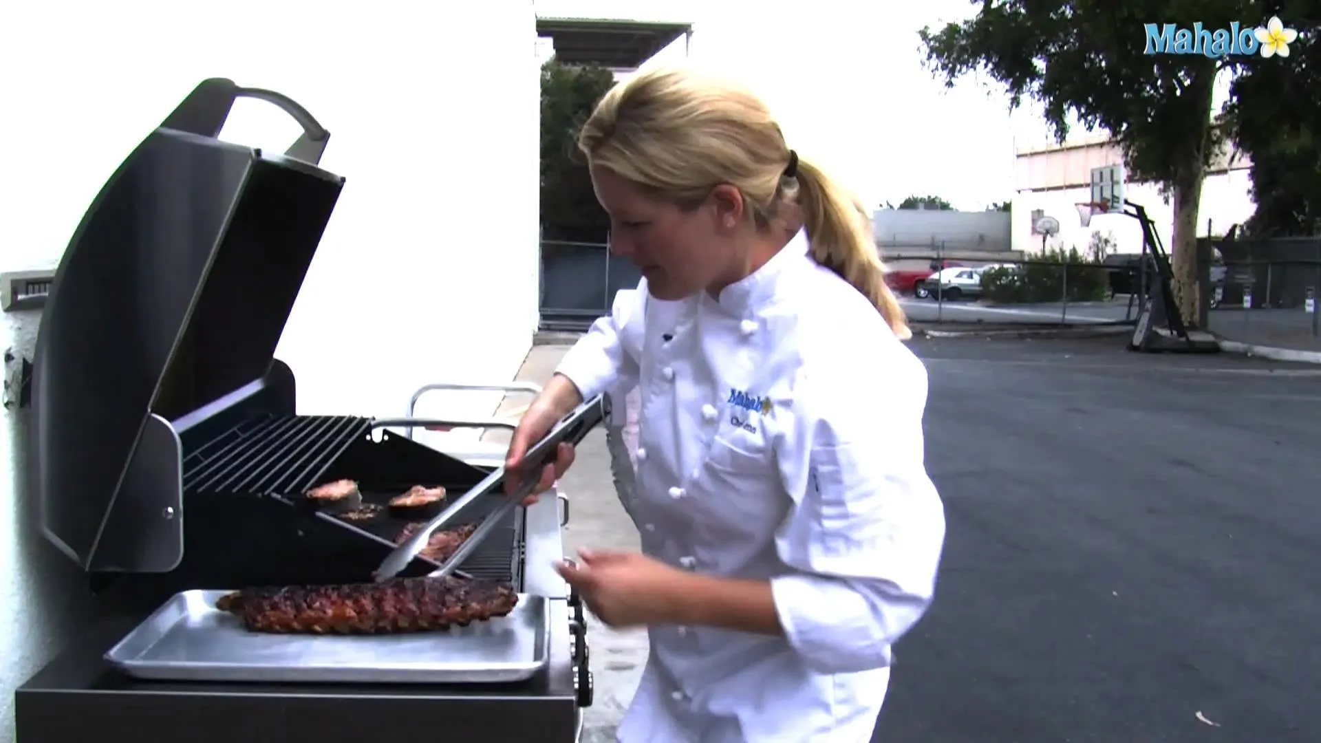 Chef grilling meat on a barbecue.