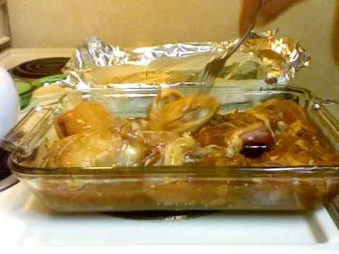 Roasted chicken in a glass baking dish with a fork.
