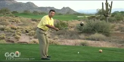 A golfer preparing to tee off on a desert golf course.