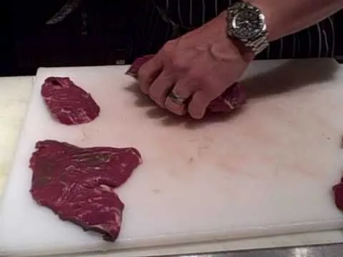Slicing raw meat on a cutting board.