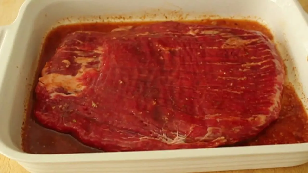 Raw marinated beef in a white dish.