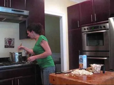 Person cooking in a modern kitchen with stainless steel appliances.