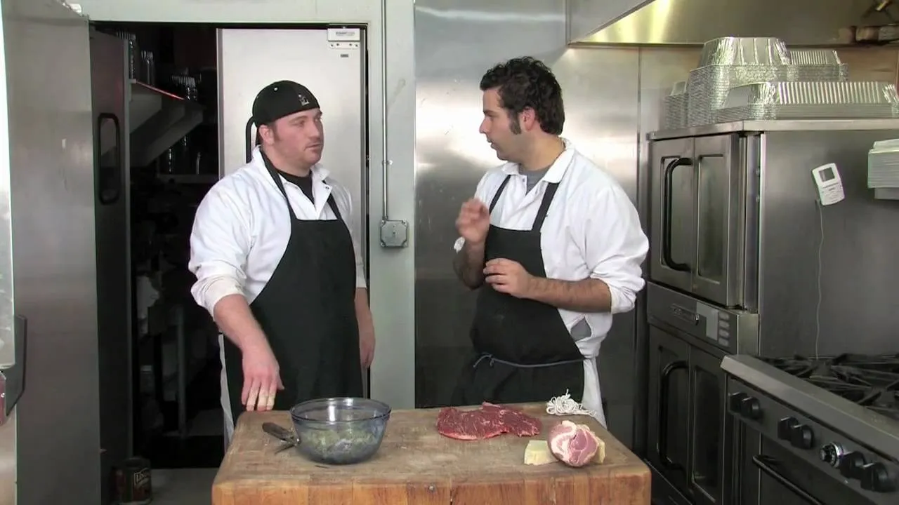 Two chefs discussing meal preparation in a kitchen.