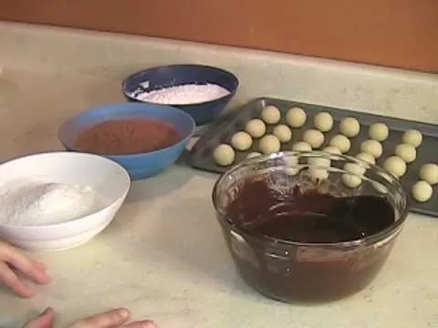 Preparation of ingredients for baking, including bowls of flour, cocoa powder, and rolled dough balls.