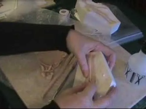 Hands preparing dough with a rolling pin on a countertop.