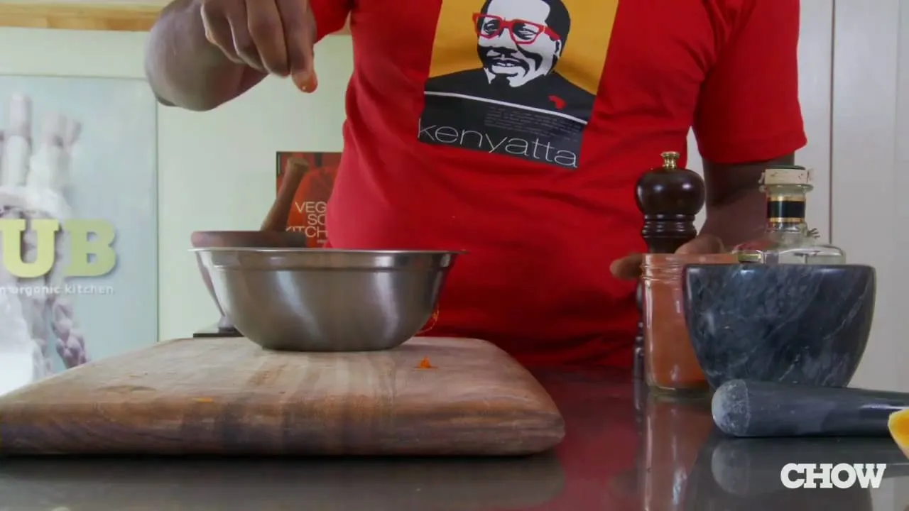 Person adding ingredients to a mixing bowl in a kitchen setting.