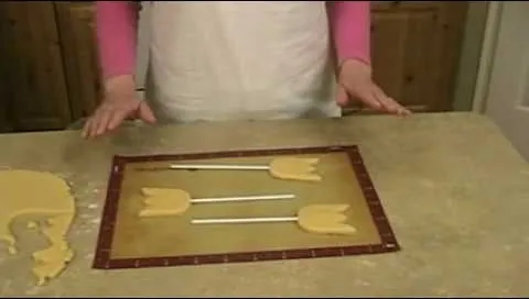 Cookie dough shaped like tulips on a baking mat.