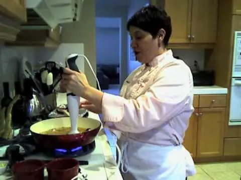 Woman using an immersion blender in a kitchen.