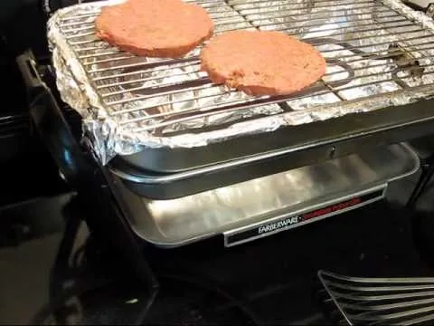Grilling two burger patties on a countertop grill.