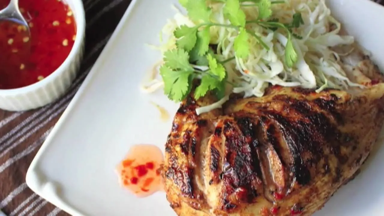 Grilled chicken with fresh herbs and dipping sauce.