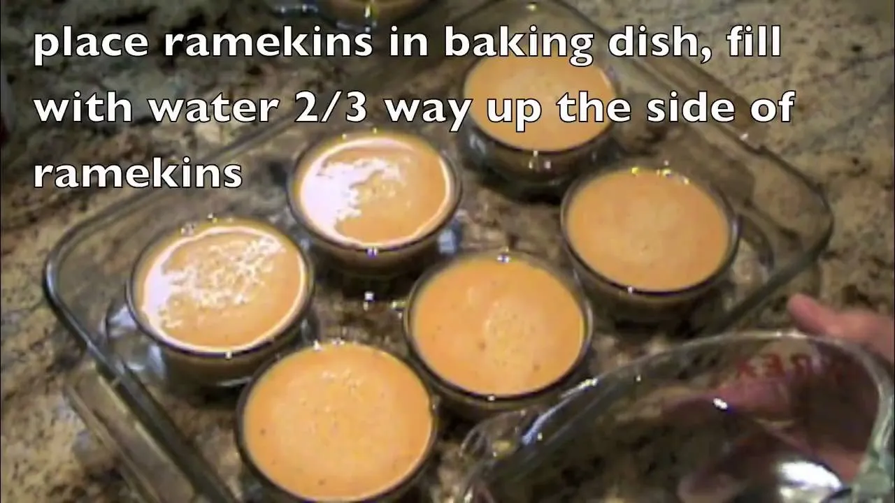 Ramekins filled with a custard mixture in a baking dish with water.